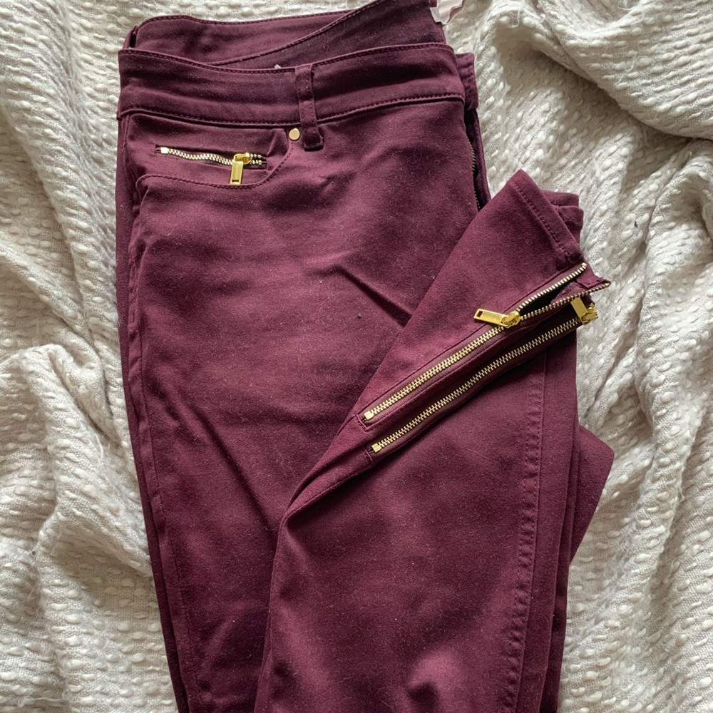 Maroon H&M jeans with gold accents.